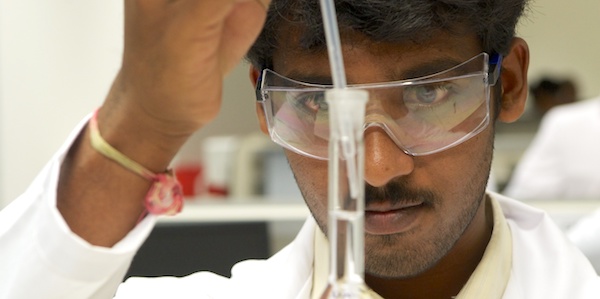 PG student with pipette and flask