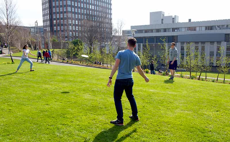 Students playing frisbee in Rottenrow Gardens