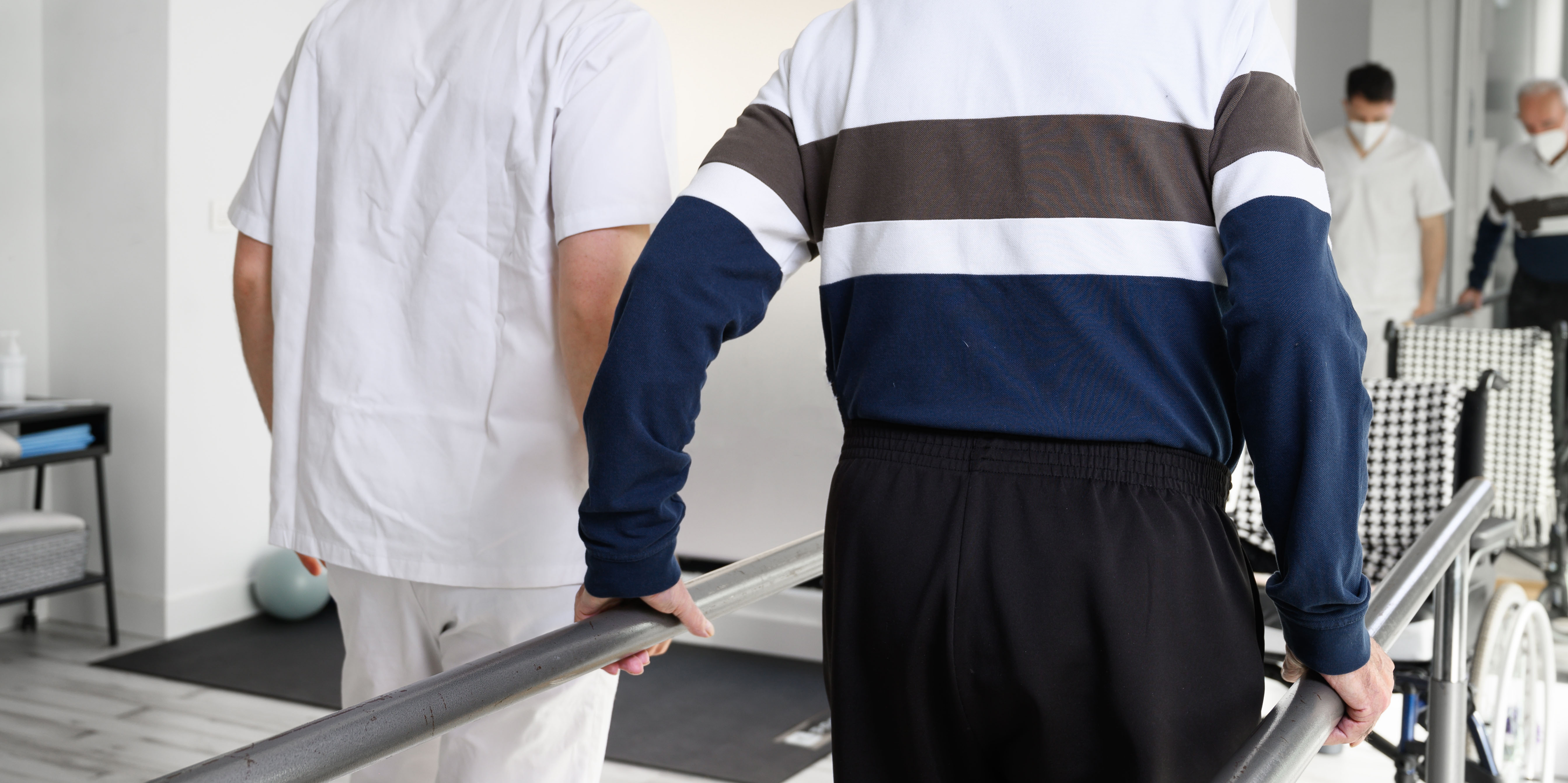 Elderly man and his nurser practicing walking after a stroke