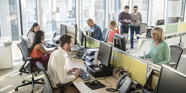 Workers using computers in modern office.