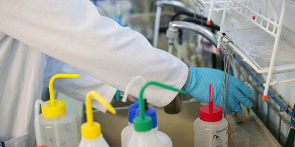 researcher works in a lab with bright coloured bottles