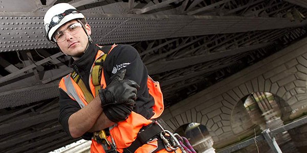 Safety worker stands in hard hat,600x300