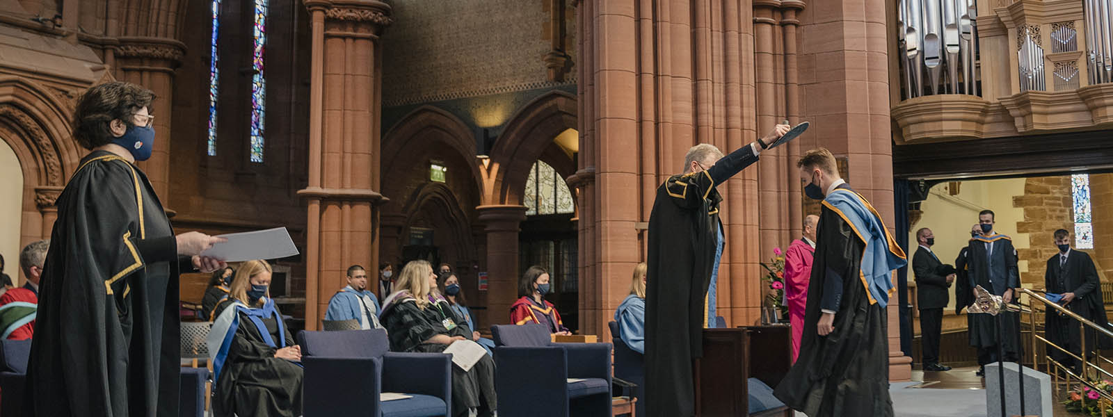 Student on stage at Graduation ceremony inside the Barony Hall.