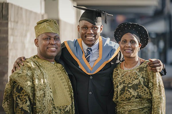 Student with two family members on their graduation day
