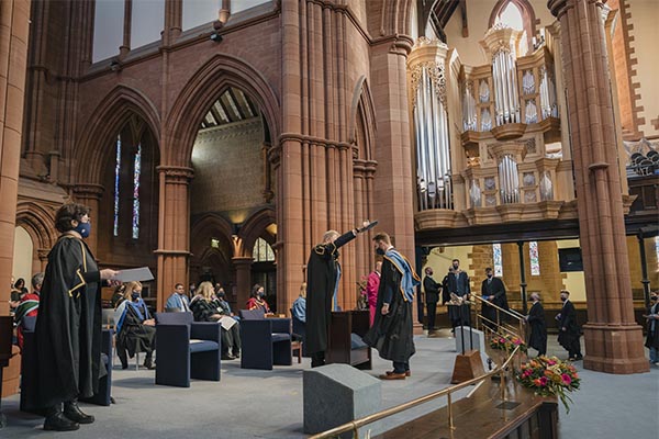 Graduate collecting their certificate at graduation ceremony in the Barony Hall