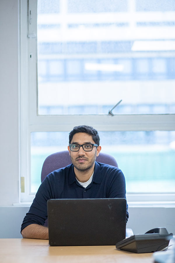 Manish Joshi sitting at a laptop.