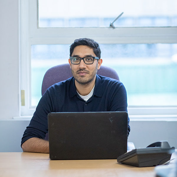 Manish Joshi sitting in front of a laptop.