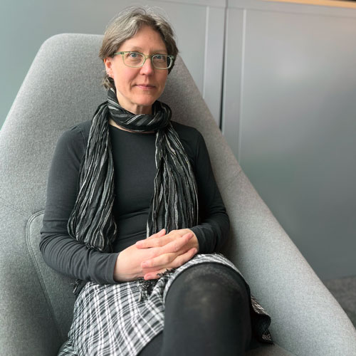 Tanja Mueller sits in a chair, smiling at the camera