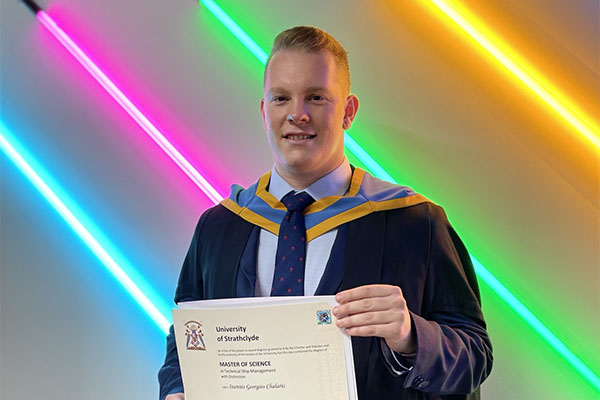 Ioannis Chalaris holding graduation certificate.