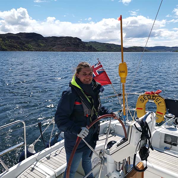 Margot Cocard at the helm of a yacht