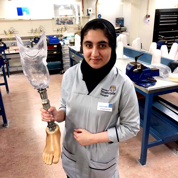 Zainab Al Balushi holding a prosthetic leg.
