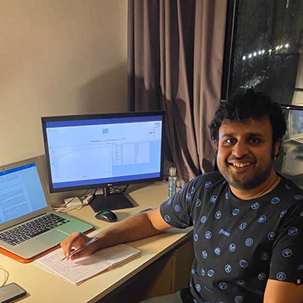 Aditya Prakash at his desk with laptop and screen