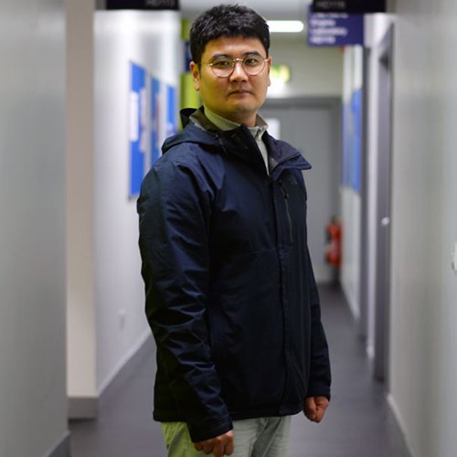 Sung il standing in the Henry Dyer corridor smiling at the camera