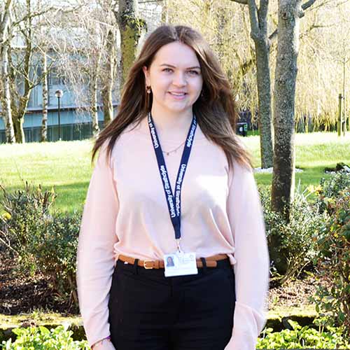 Amy Hyslop, PhD student, standing in University gardens