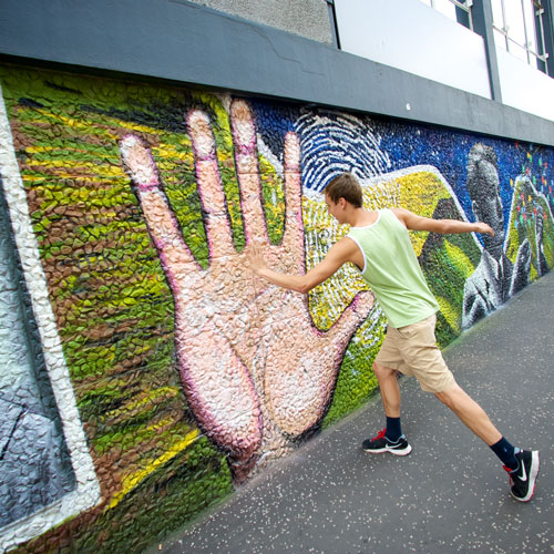 student hi=fives a large hand painted on the strathclyde wonderwall
