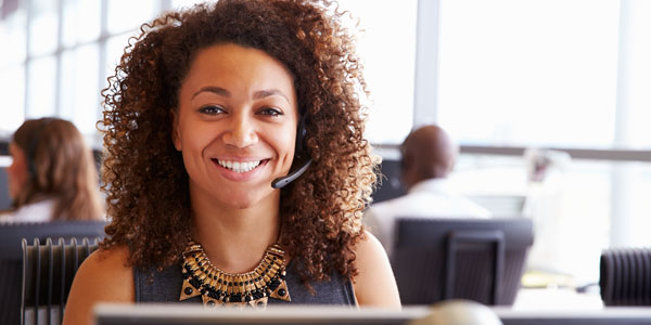 a woman with a headset smiles at the camera