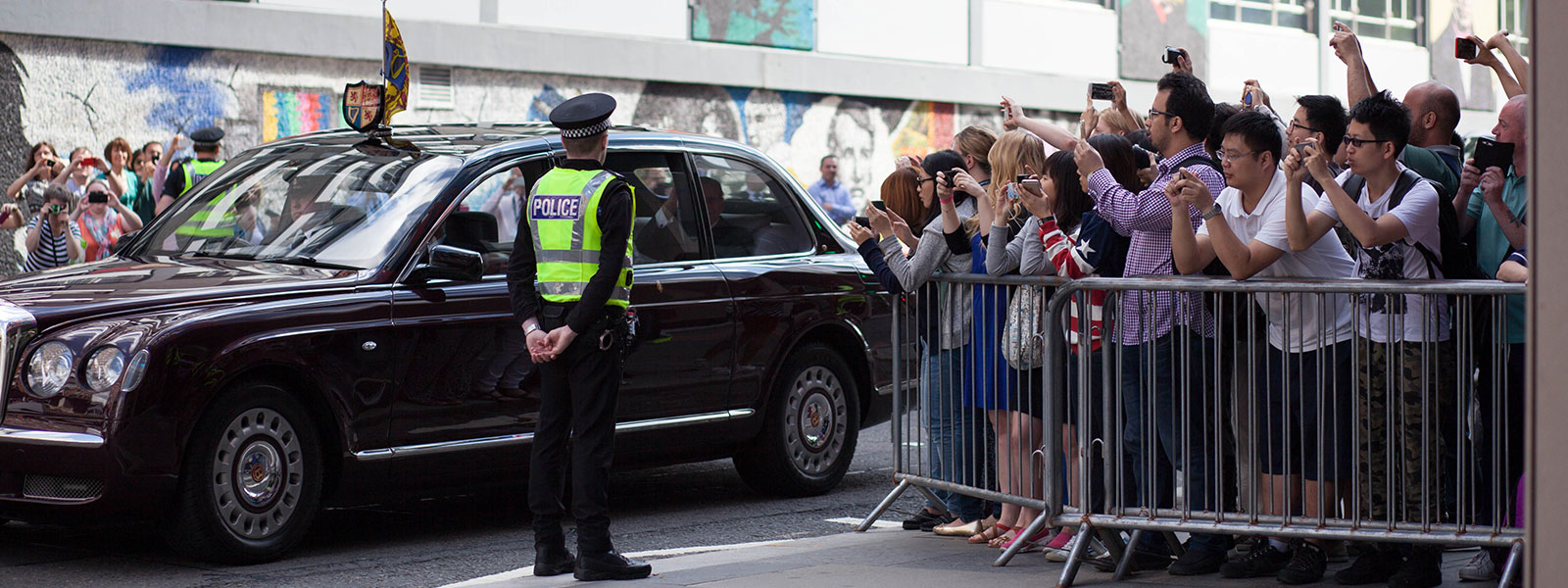 The crowds eagerly await the arrival of The Queen and The Duke of Edinburgh. 