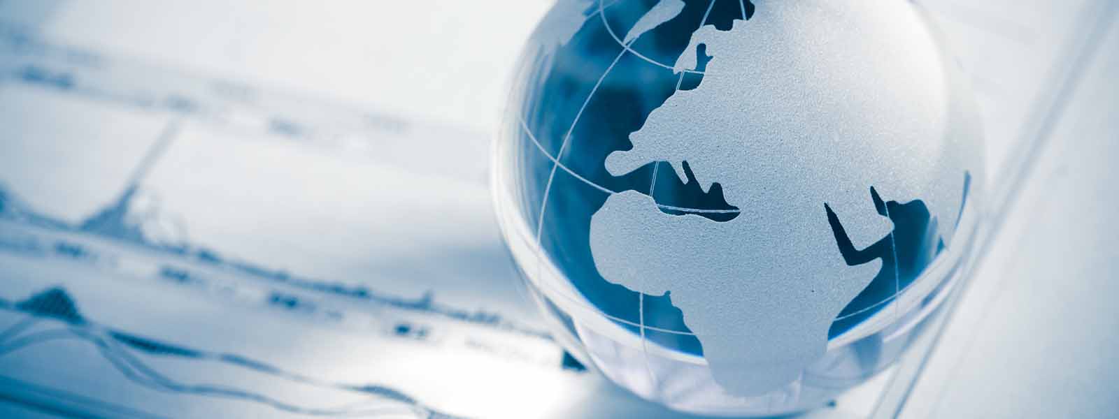Glass globe of a map of Europe map and stock market chart on newspaper background