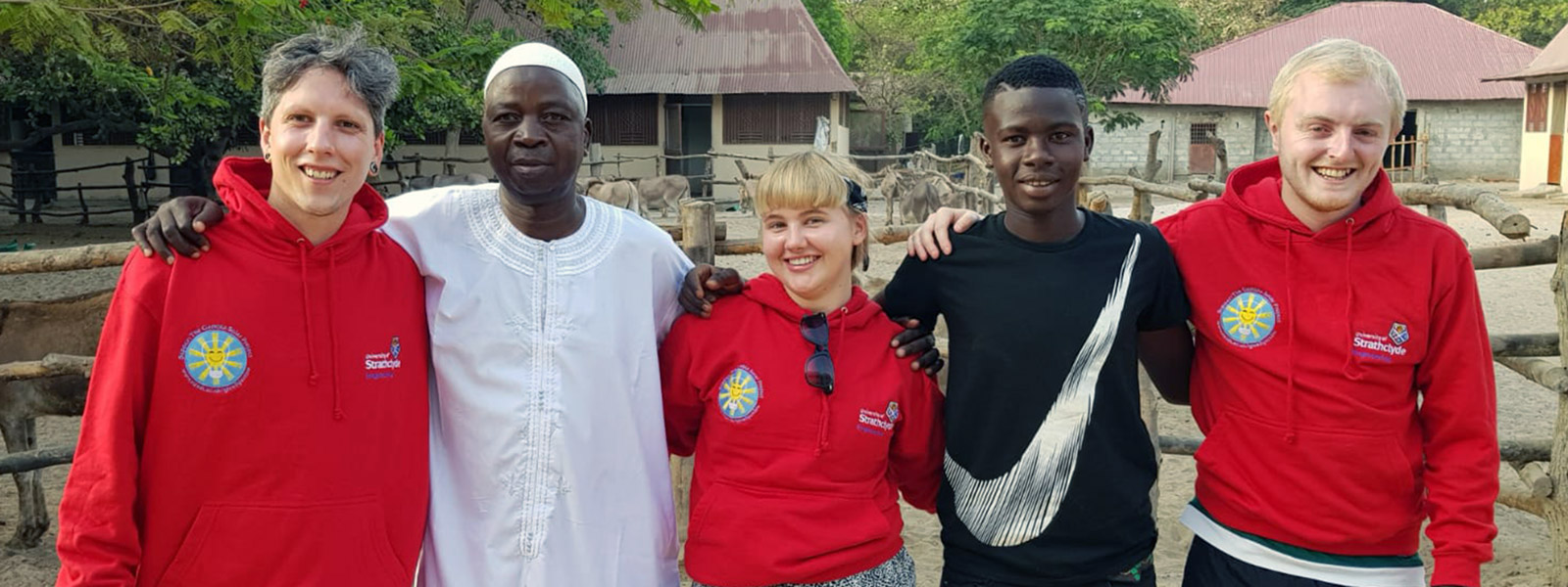 Strathclyde students Callum Taylor, Emma Tate and Steven Nolan with Kembujeh with local people in Kembujeh.