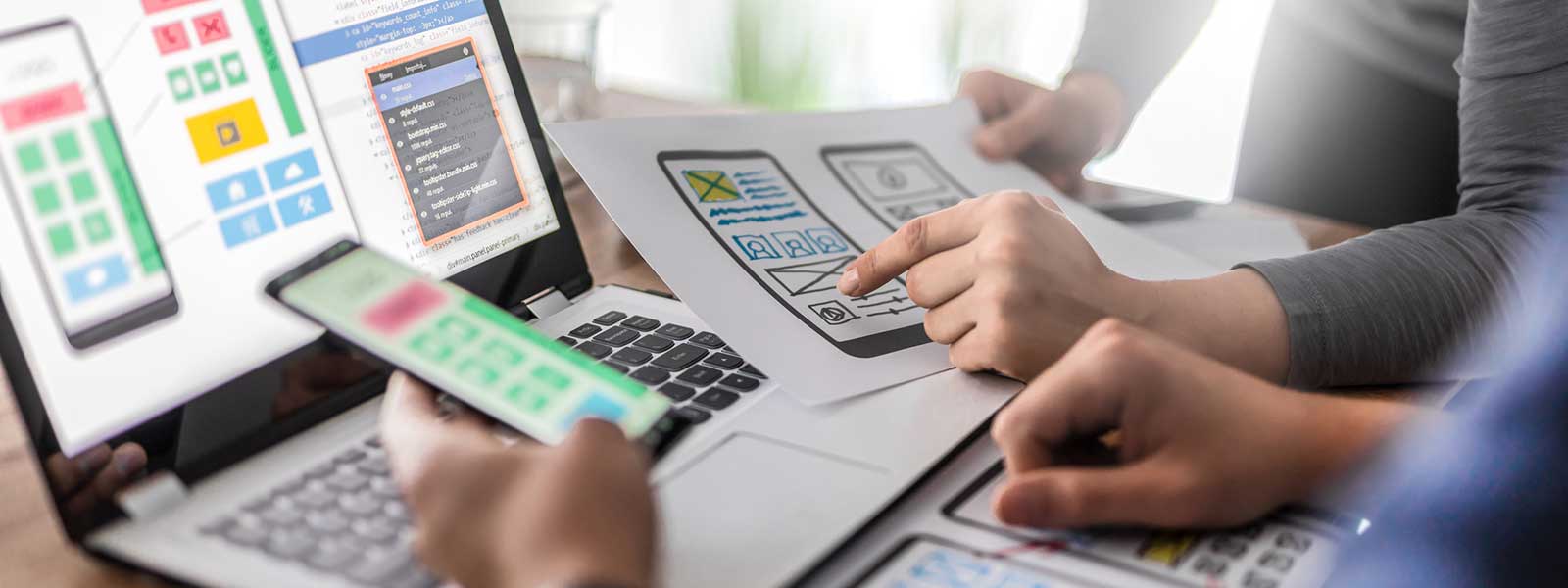 Designers on a laptop working on UX design for a mobile app.
