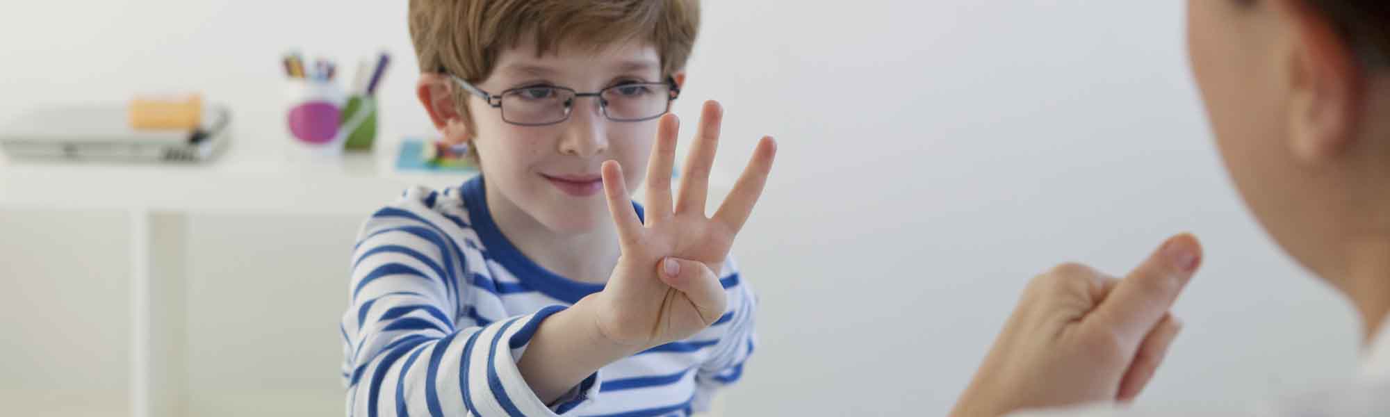 Speech therapist with child signalling hand gestures