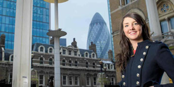 Female student in London, Gherkin building in background.