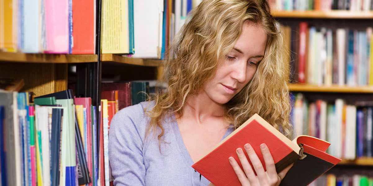 Student in library with books.