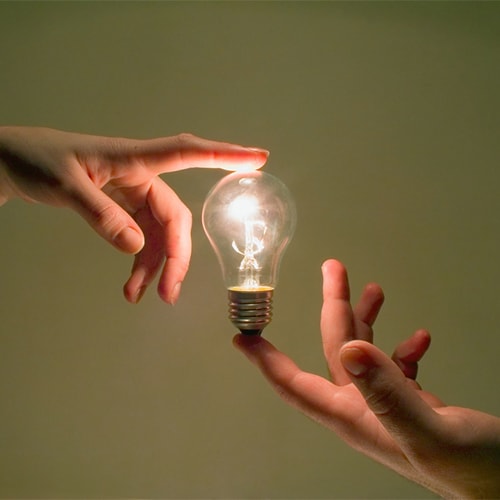 Hands holding a lightbulb