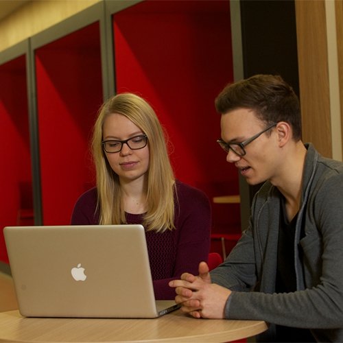 Two students looking at a laptop