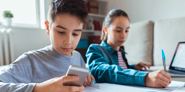 Boy and girl use mobile phone and laptop