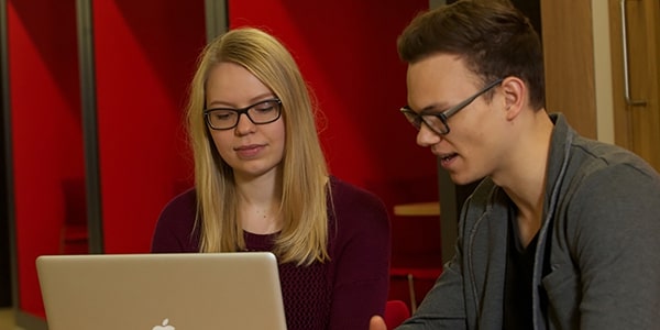 Two students looking at a laptop/