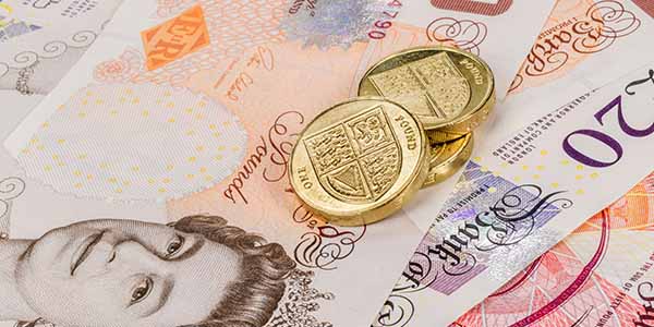 UK currency - pound coins sitting on top of bank notes