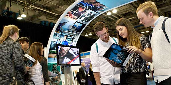 Three students looking at a brochure in the middle of the Scottish Careers Fair