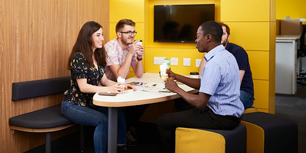 Group of students talking round a table.