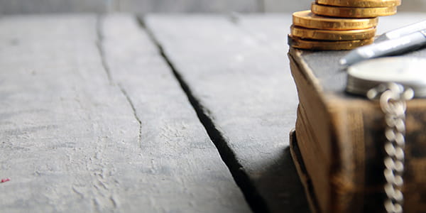 Coins on top an old book on a wooden vintage table