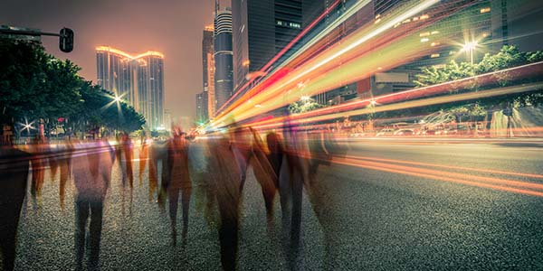 blurred people and traffic on a street at night
