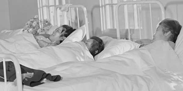 Black and white photo of patients in a hospital bed
