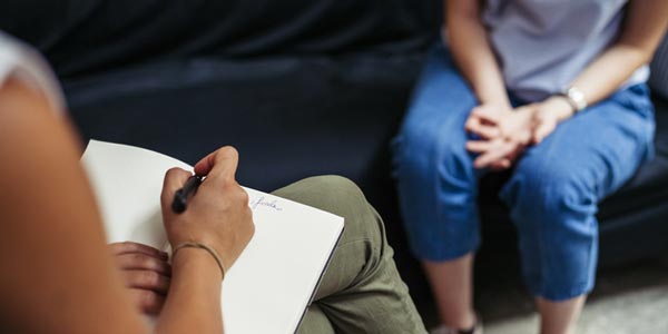 Person taking notes whilst talking to someone.