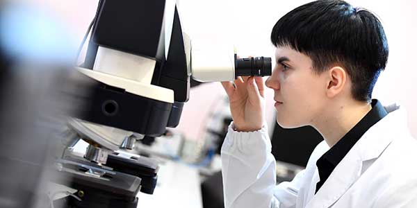 Student looking through a microscope.