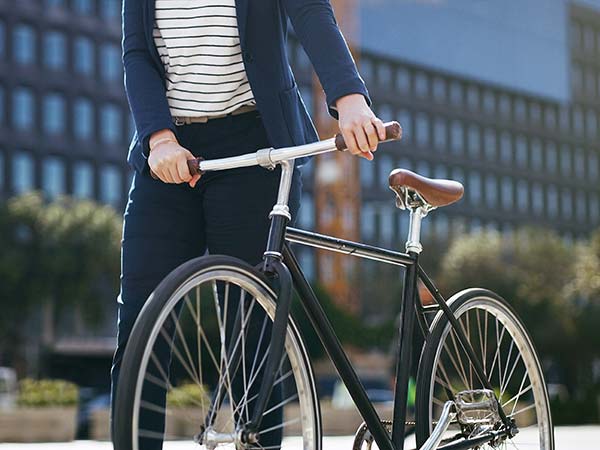 Person walking with bicycle on street.