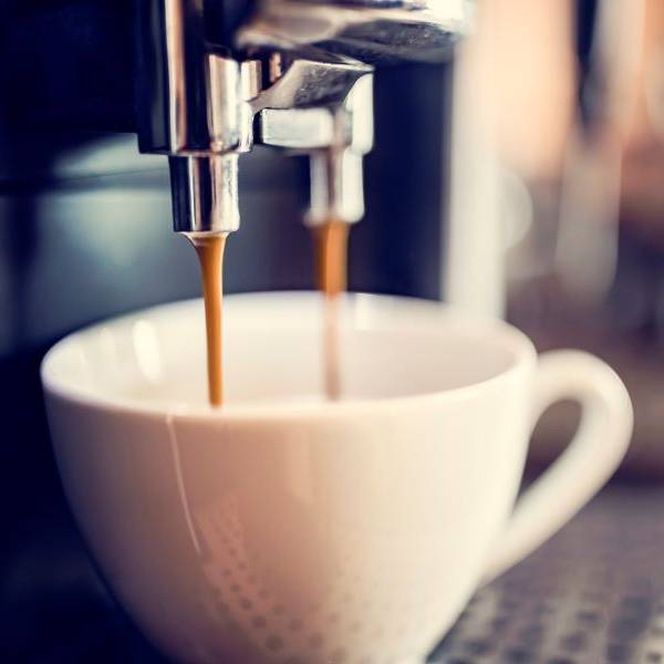 Coffee being filtered into a cup from a coffee machine