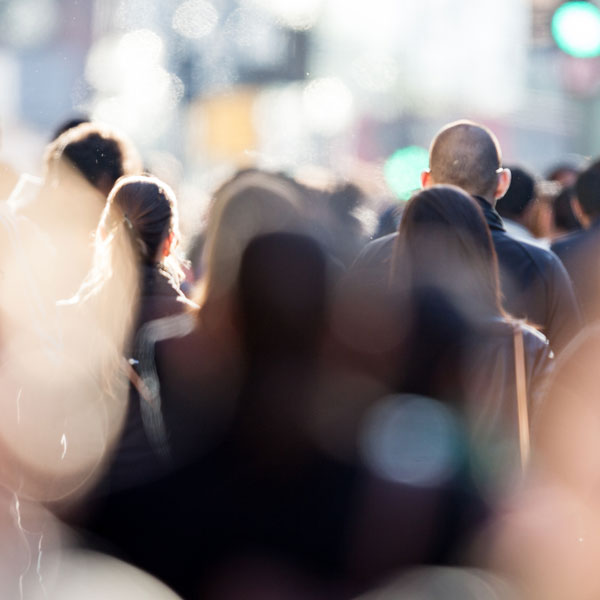 a blurred shot from behind of a crowd of people walking