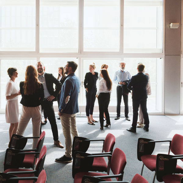 a group of people stand up chatting with each other