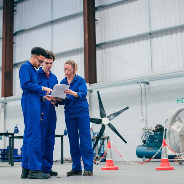 a group of engineers stand together in discussion