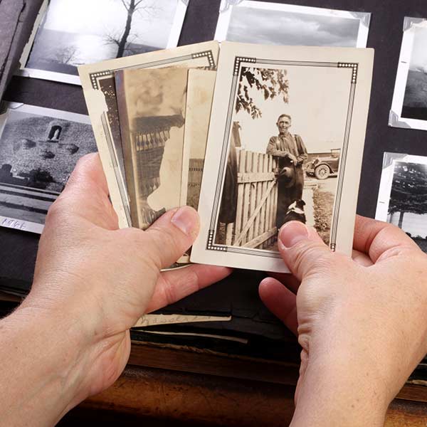 Hands holding old photographs.