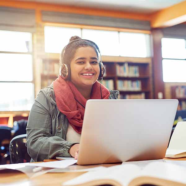 Student wearing headphones while using laptop