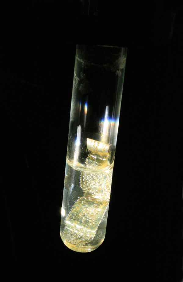 A test tube with clear liquid and a strip of metal inside