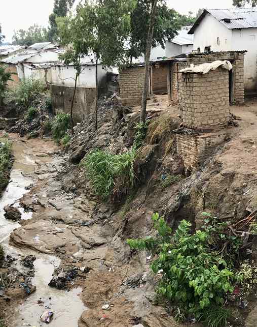 A muddy river runs past some houses 