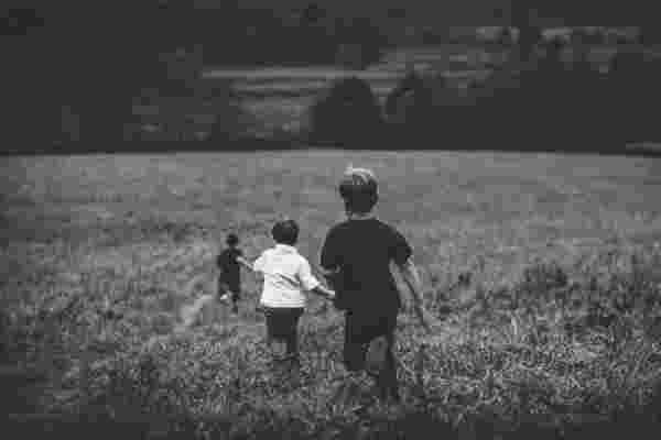 Three children running in a field