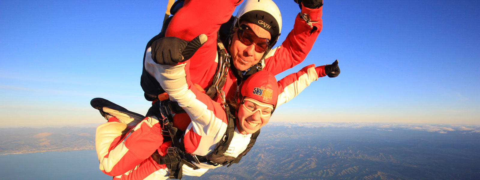 two people mid-skydive two people mid-skydive